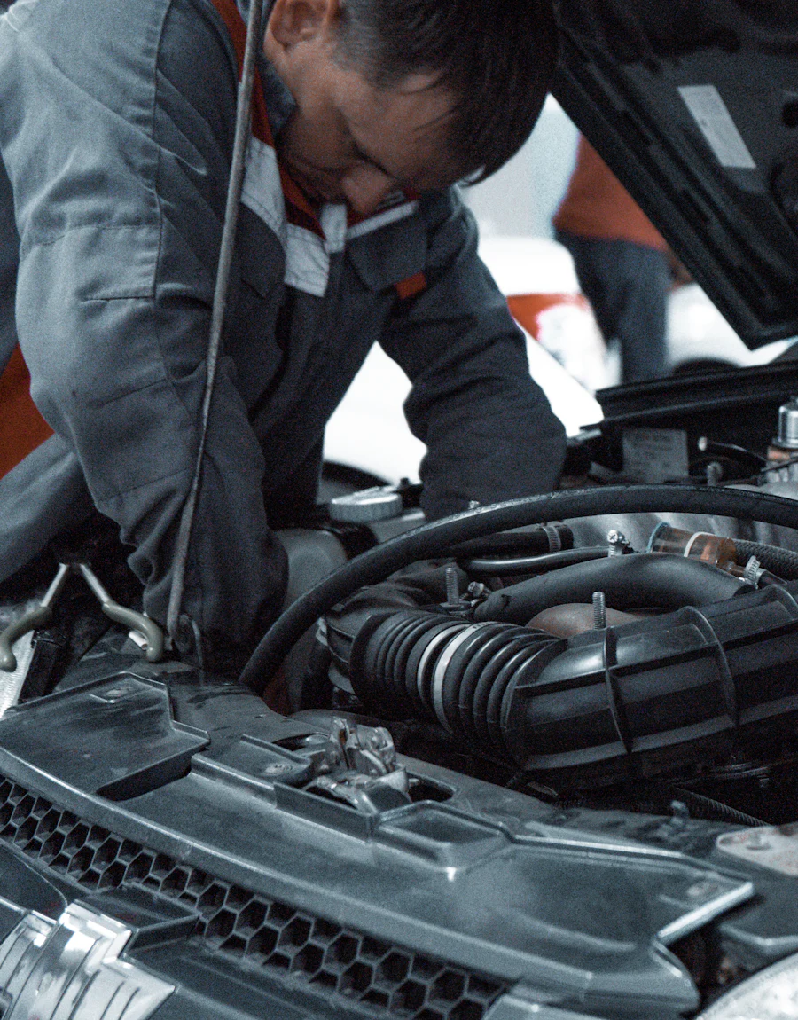 Mecanic verificând compartimentul motor al unui automobil în atelier